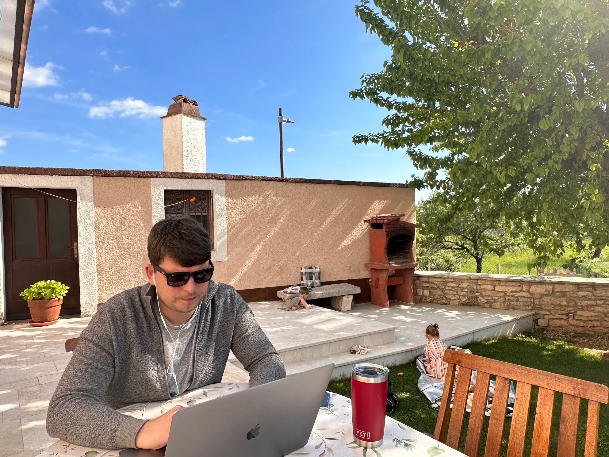 Me working outside on a sunny day in Croatia in early May while the kids are playing in the background.