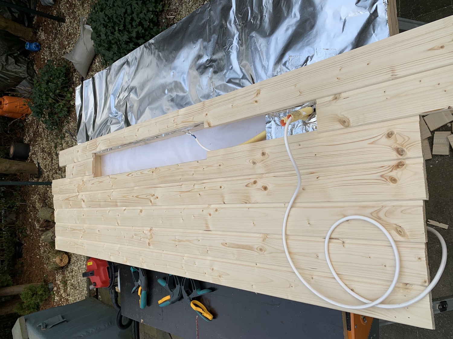 Testing the electric conduit with some electric wire. Also notice the cutout in the middle for the infrared heater to go in.